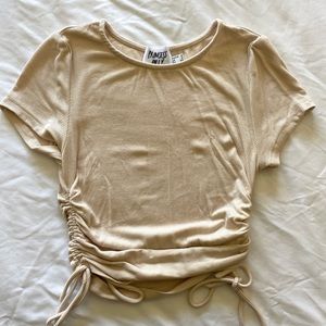 beige short-sleeve top, cropped. cinched sides are adjustable.
